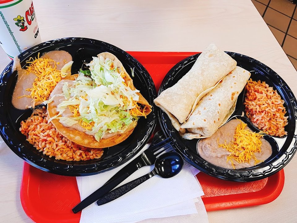 Breakfast plates and burritos on a menu board.